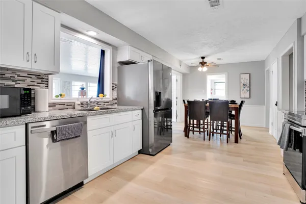 a kitchen with stainless steel appliances a refrigerator sink and cabinets