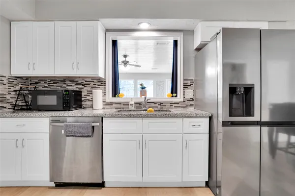 a kitchen with stainless steel appliances granite countertop a stove a sink and a refrigerator