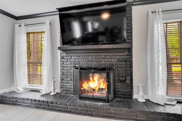 a living room with a fireplace and a flat screen tv