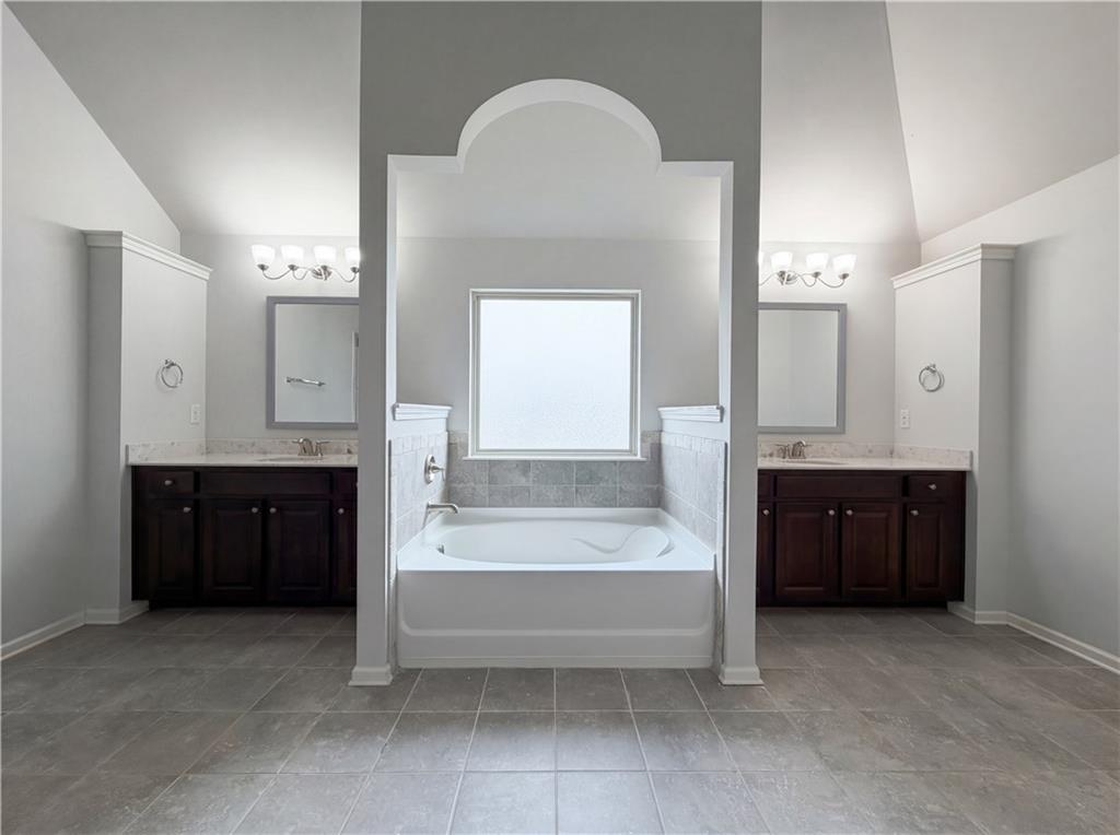 1549 Harlequin Way Stockbridge, GA 30281 - Photo 18 of 30 a spacious bathroom with a tub double sink shower and mirror