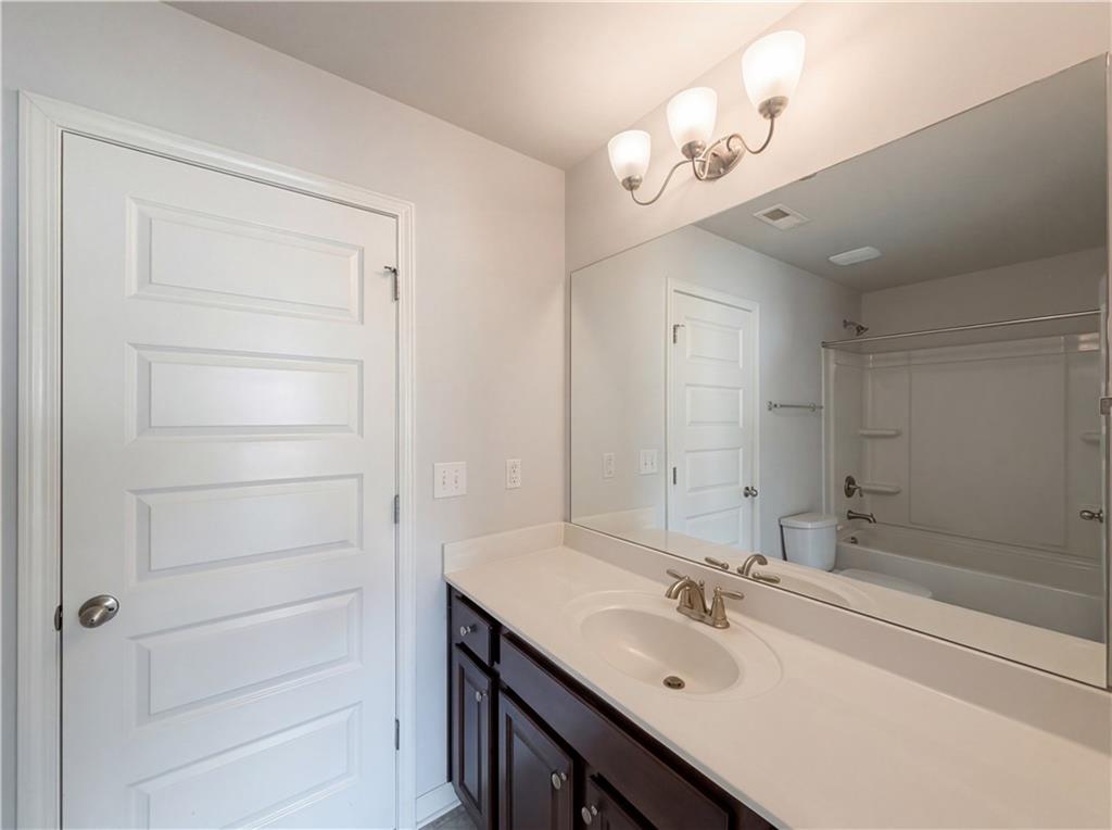 1549 Harlequin Way Stockbridge, GA 30281 - Photo 29 of 30 a bathroom with a sink a vanity and a mirror
