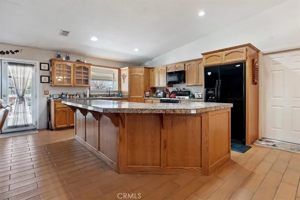 a kitchen with stainless steel appliances granite countertop a refrigerator a sink and a stove