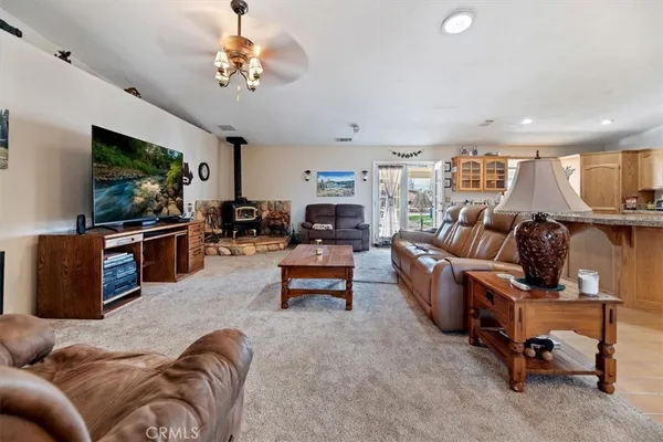 a living room with furniture kitchen view and a flat screen tv