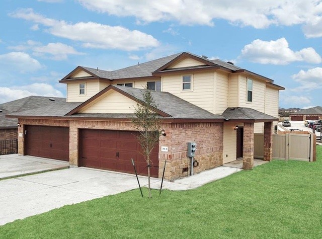 a front view of a house with a yard and garage