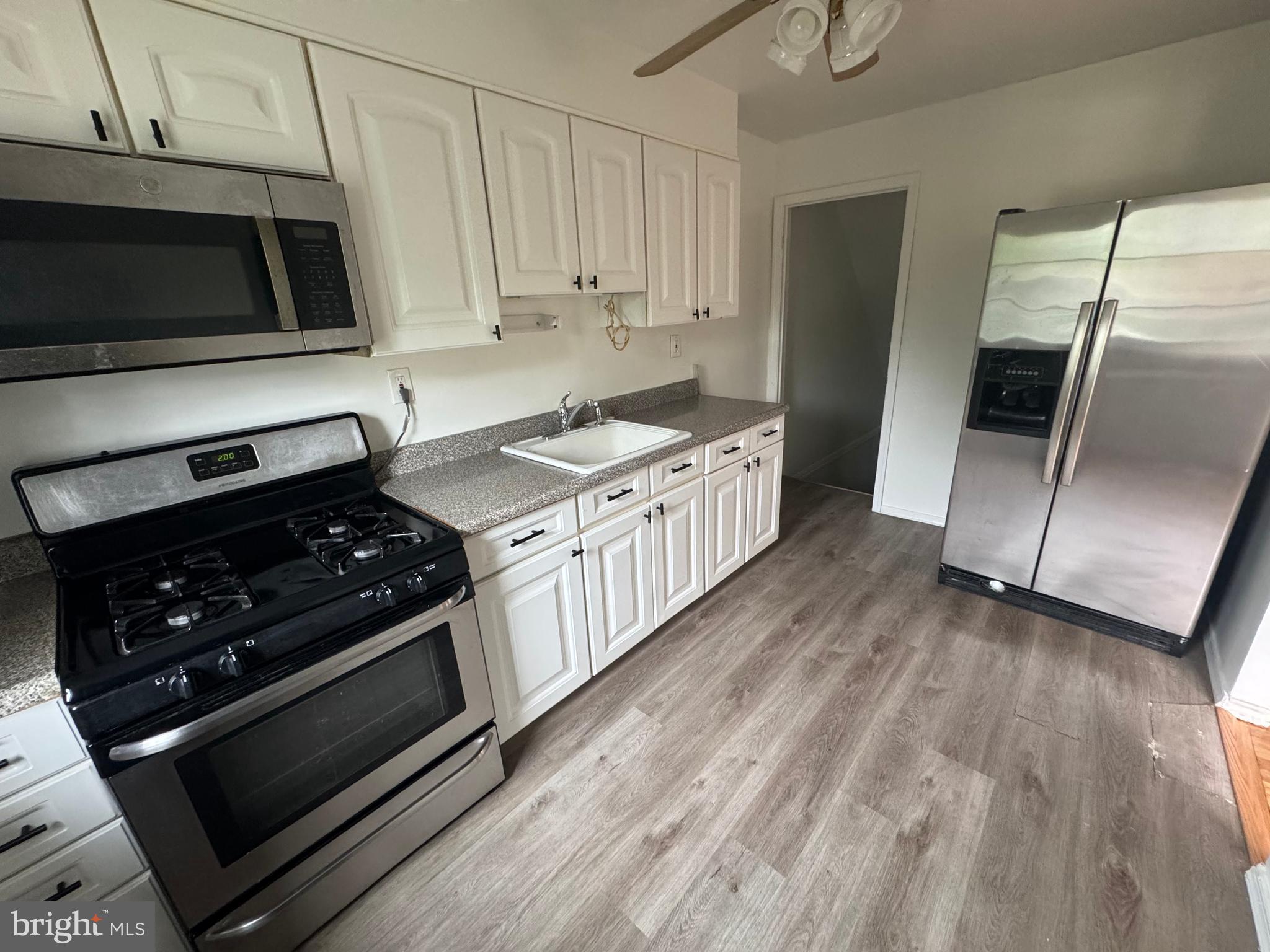 2128 Cockspur Road Middle River, MD 21220 - Photo 5 of 28 a kitchen with a stove a microwave and a refrigerator