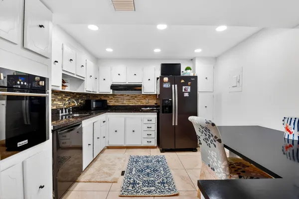 a kitchen with stainless steel appliances white cabinets and a refrigerator