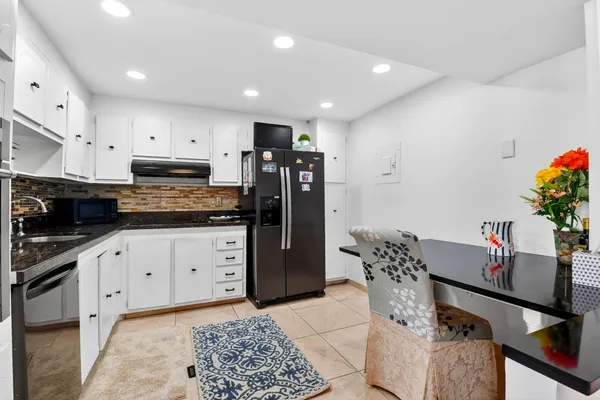 a kitchen with stainless steel appliances granite countertop a stove a sink and a refrigerator