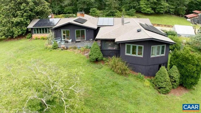 a aerial view of a house with swimming pool next to a yard