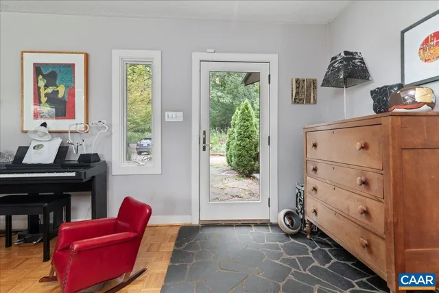 a living room with furniture chandelier and a large window