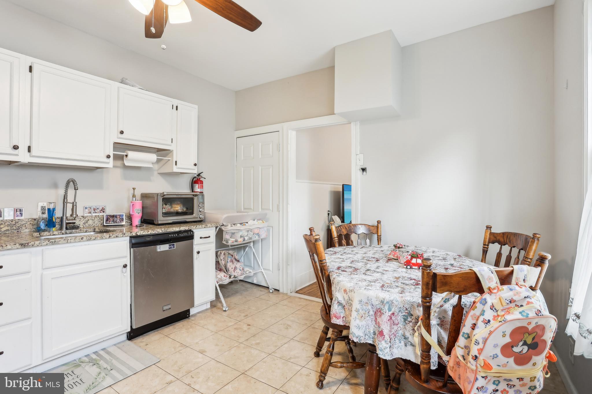 705 Burlington Avenue Delanco, NJ 08075 - Photo 11 of 41 a kitchen with stainless steel appliances granite countertop a sink a stove a dining table and chairs with white cabinets
