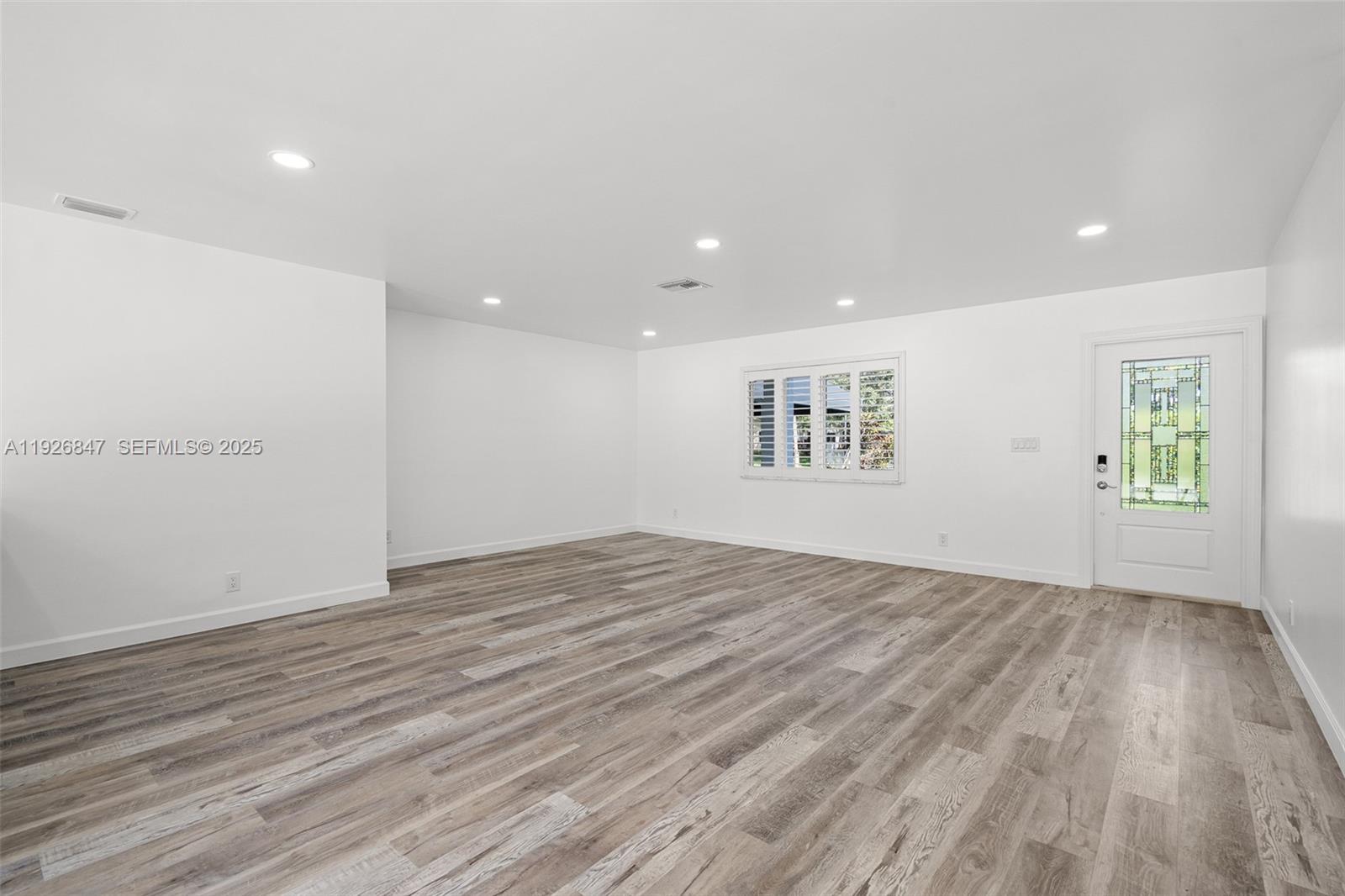 14330 Southwest 16th Street Davie, FL 33325 - Photo 11 of 53 an empty room with wooden floor and windows