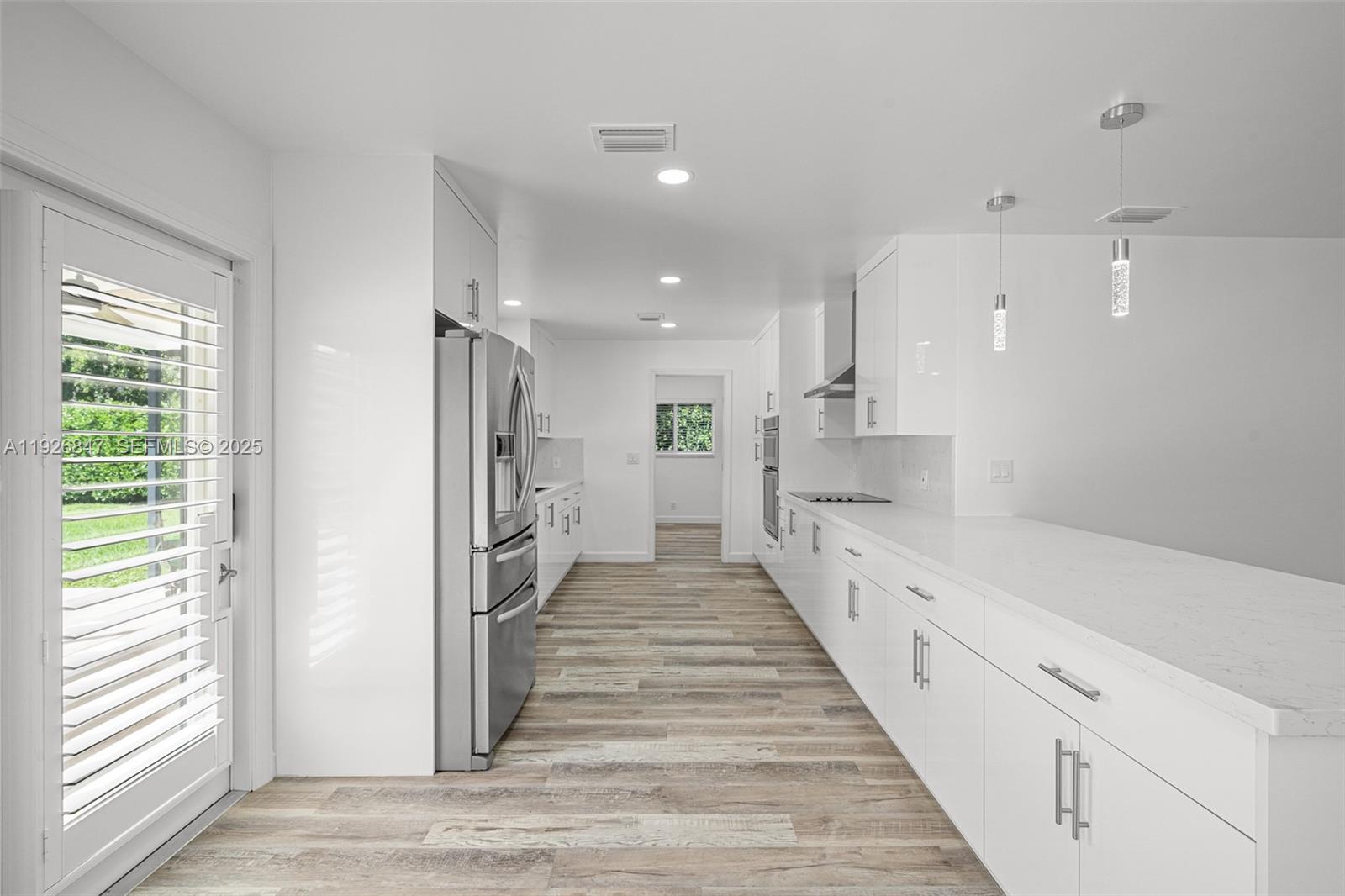 14330 Southwest 16th Street Davie, FL 33325 - Photo 19 of 53 a hallway with white cabinets and wooden floor