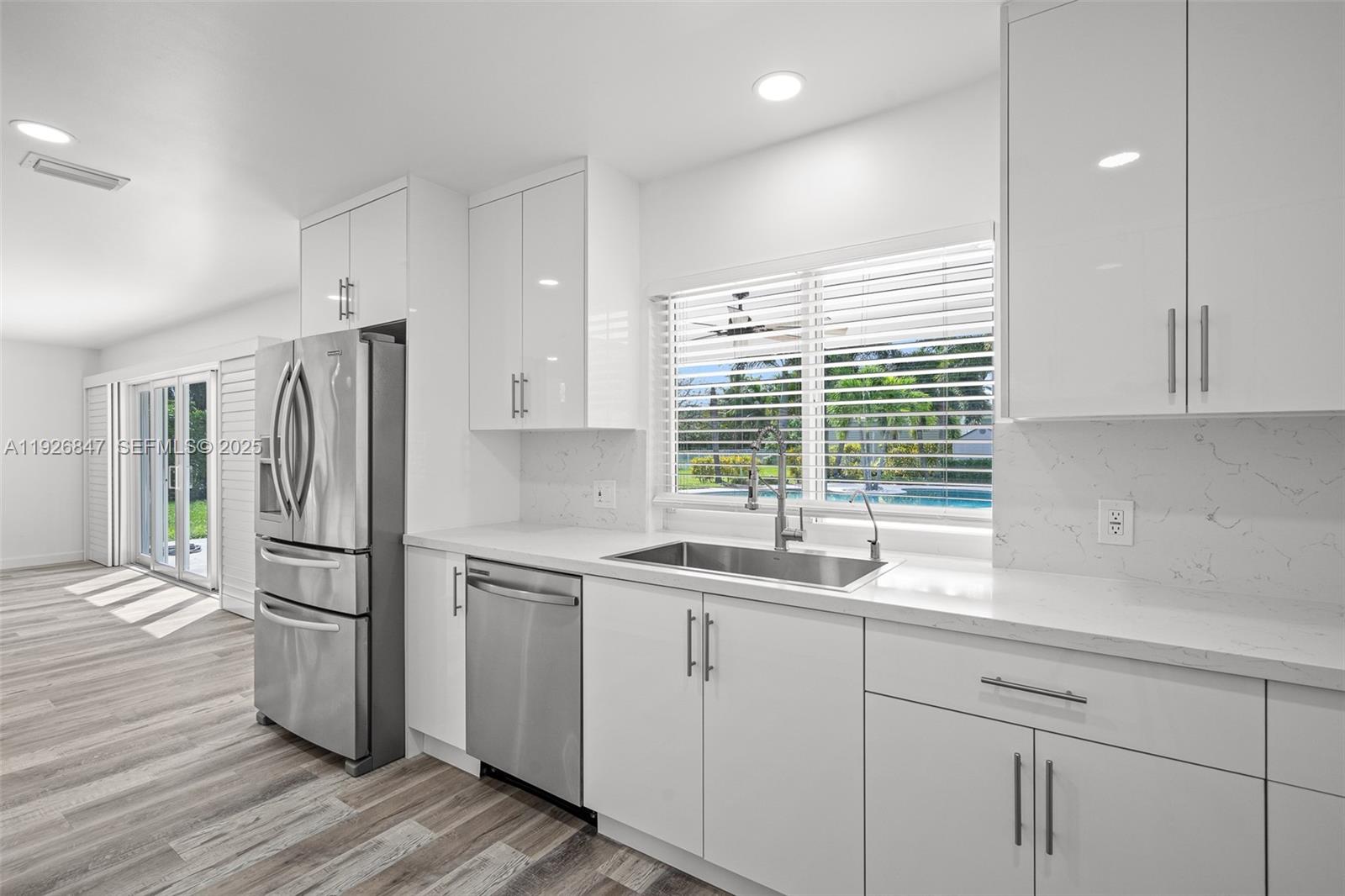 14330 Southwest 16th Street Davie, FL 33325 - Photo 23 of 53 a kitchen with a sink a refrigerator and window