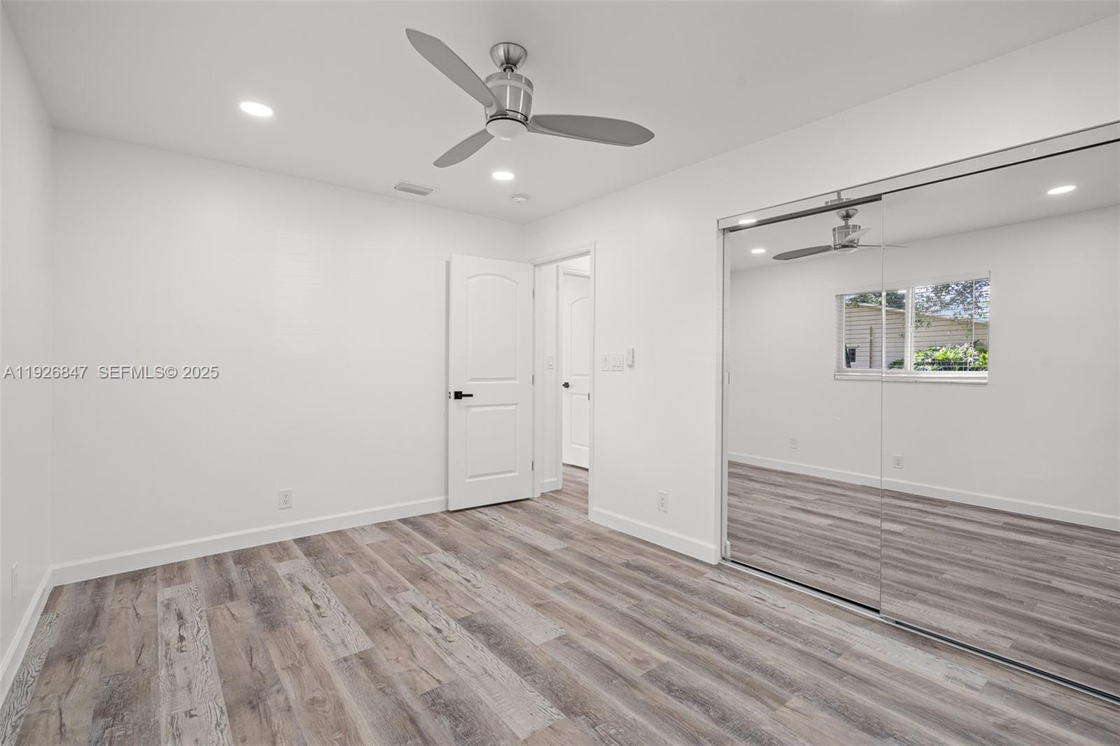 14330 Southwest 16th Street Davie, FL 33325 - Photo 31 of 53 an empty room with wooden floor a ceiling fan and closet