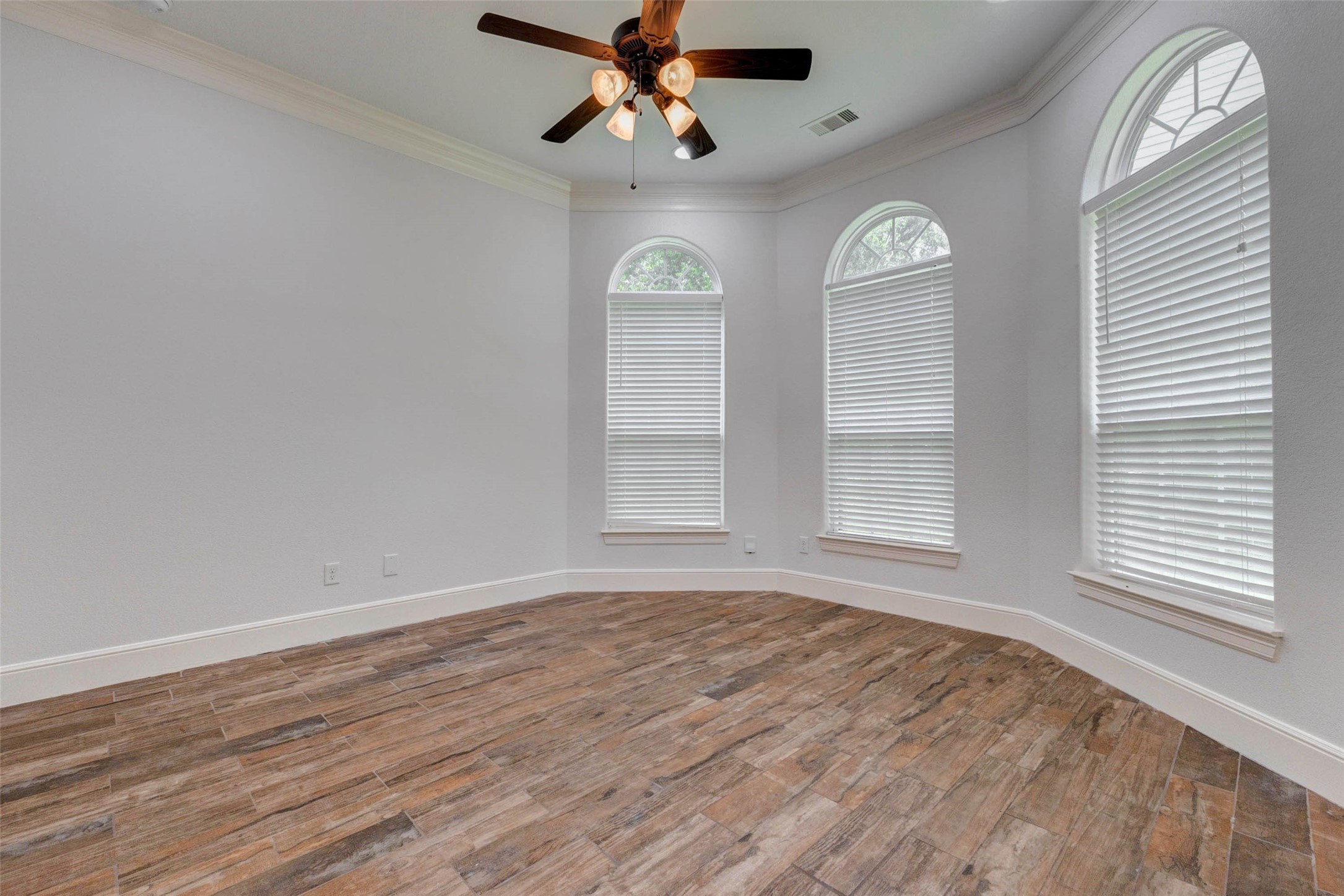 5327 Whitmore Fulshear, TX 77441 - Photo 22 of 50 Privately situated on the first floor, the spacious home office offers an ideal work-from-home setting complete with elegant architectural details and beautiful arched windows.