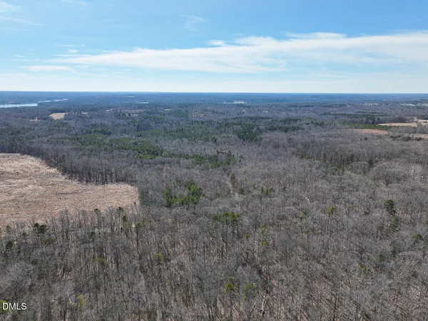 an aerial view of residential house with outdoor space and trees all around