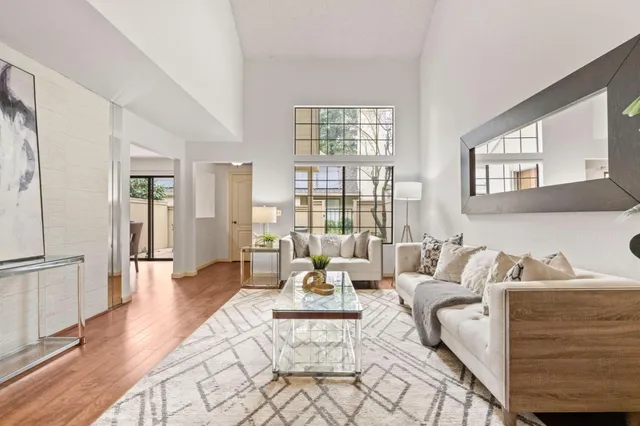 a living room with furniture white walls and wooden floor