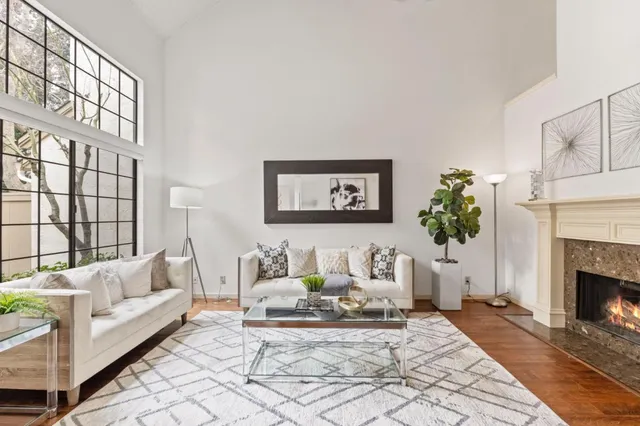a living room with furniture a fireplace and a large window