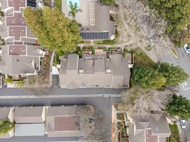 an aerial view of a house with a yard and large tree