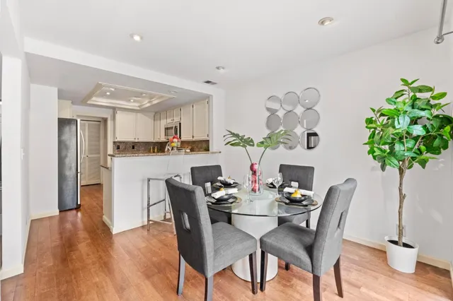 a dining room with furniture potted plants and wooden floor