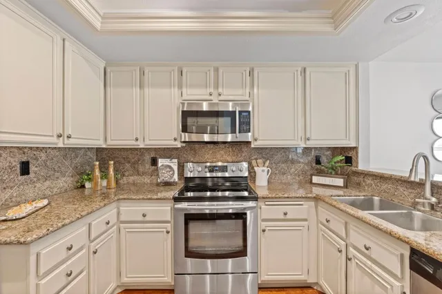 a kitchen with granite countertop white cabinets and white appliances