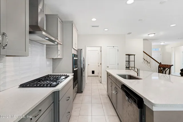 a kitchen with stainless steel appliances a sink a stove a refrigerator and cabinets