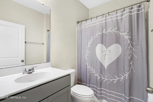 a bathroom with a granite countertop sink toilet a mirror a vanity and shower