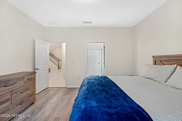 a spacious bedroom with a bed and wooden floor