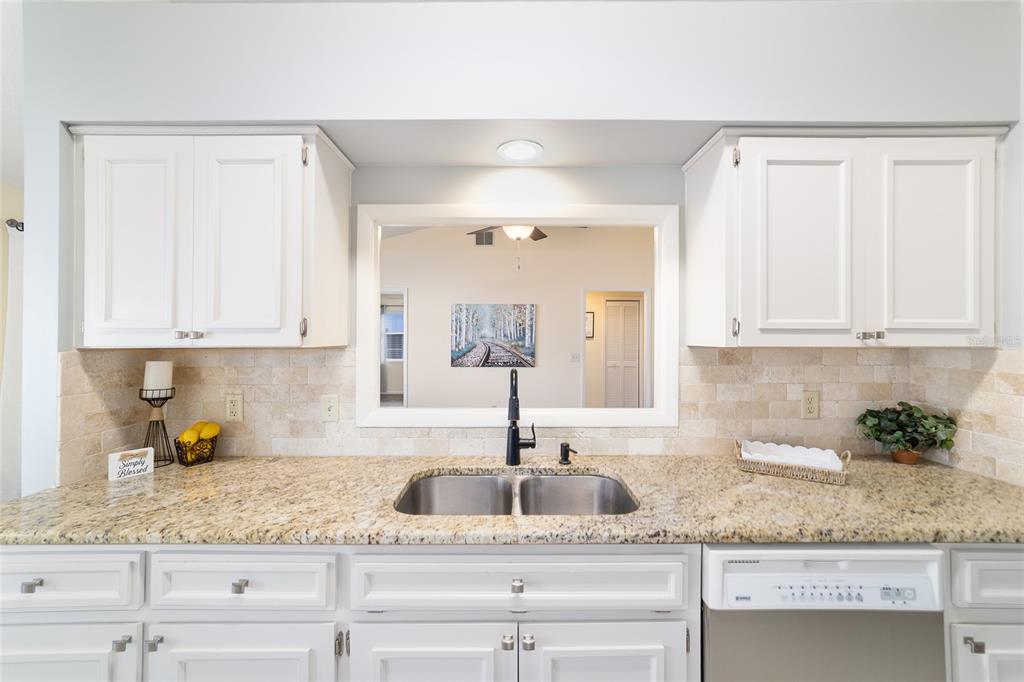 4385 North Bacall Loop Beverly Hills, FL 34465 - Photo 23 of 60 a kitchen with granite countertop a sink and cabinets