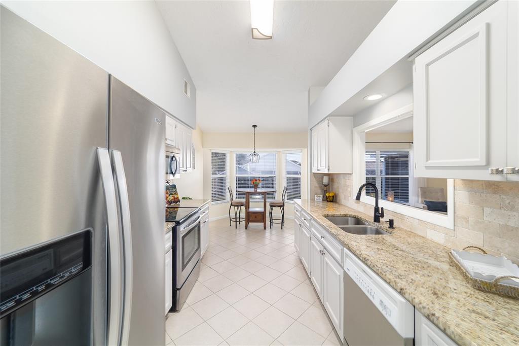 4385 North Bacall Loop Beverly Hills, FL 34465 - Photo 24 of 60 a kitchen with granite countertop a refrigerator a sink a stove and chairs