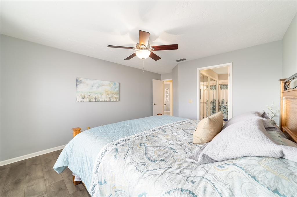 4385 North Bacall Loop Beverly Hills, FL 34465 - Photo 32 of 60 a bedroom with a large bed and a chandelier