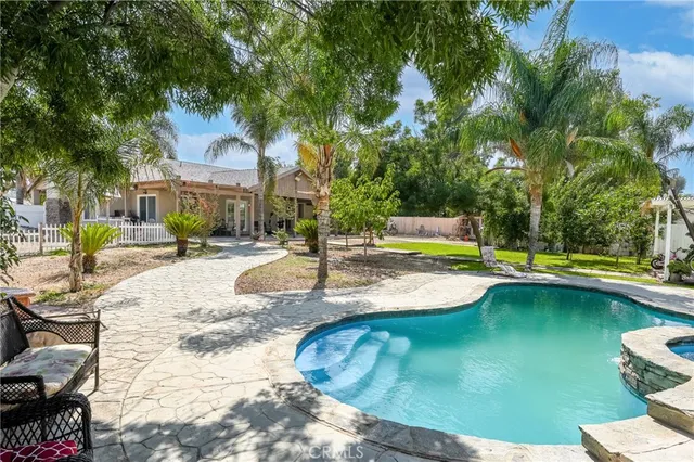 a view of a house with a yard covered with snow and plants