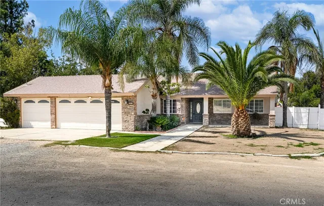 a view of a house with a yard and coconut trees