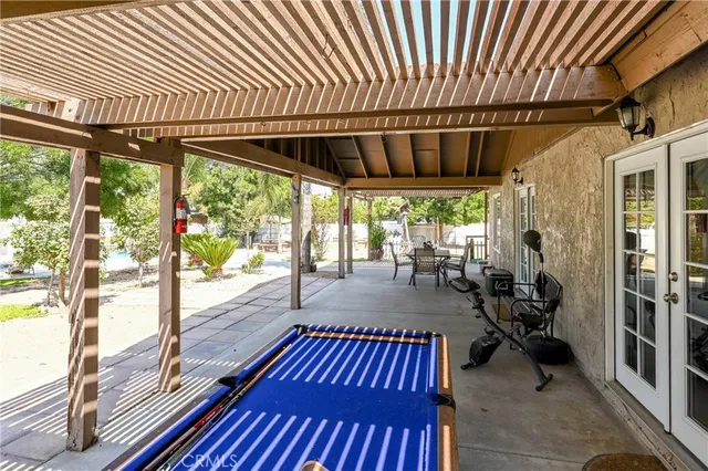 a view of a patio with table and chairs potted plants and large tree