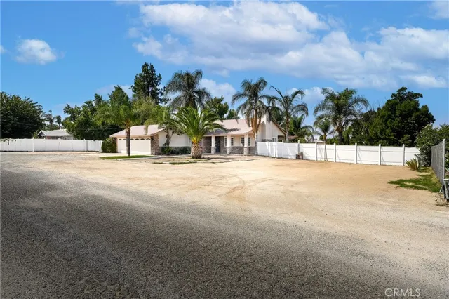 a view of a house with a small yard plants and palm trees