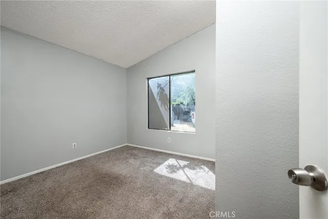 a view of empty room with floor to ceiling window and an outdoor view