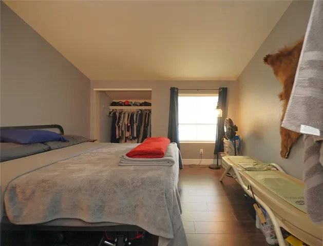 a bedroom with a bed and wooden floor