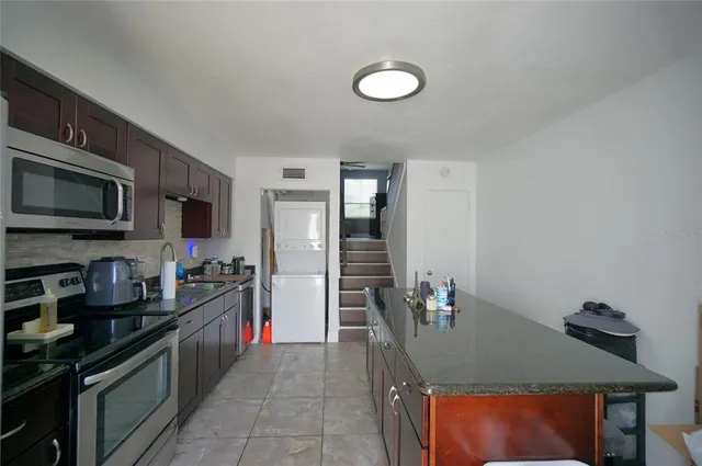 a kitchen with stainless steel appliances granite countertop a stove top oven a sink dishwasher and a microwave oven on the blue kitchen countertops