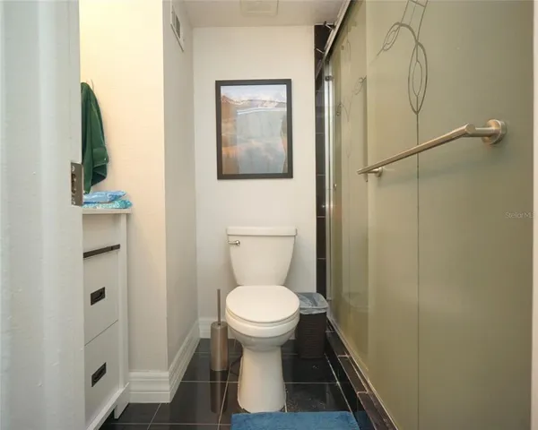 a bathroom with a toilet and a shower