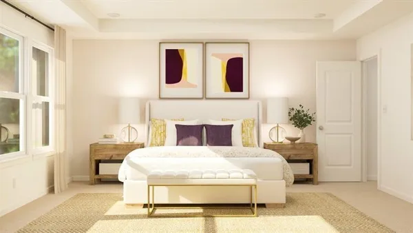 a bedroom with a large bed a potted plant and a fireplace