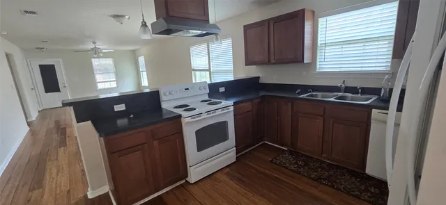 a kitchen with stainless steel appliances granite countertop a stove a sink and a microwave