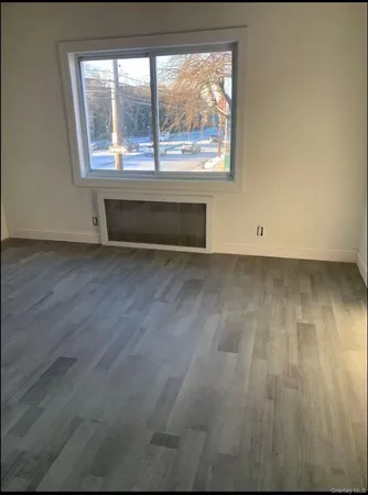 an empty room with wooden floor and a fireplace