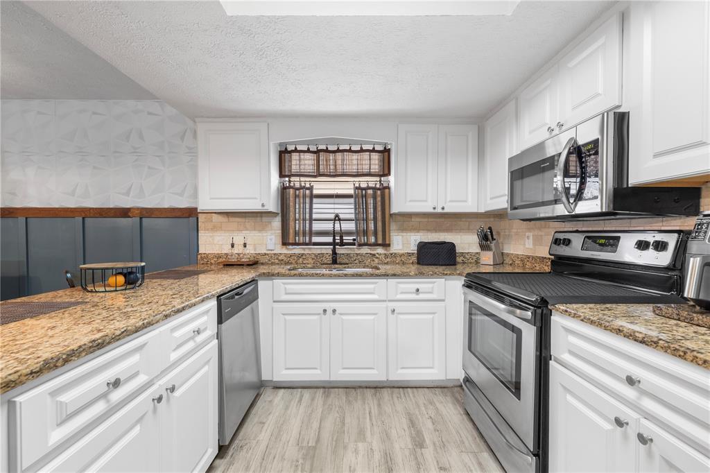1005 Mook Street Brandon, FL 33510 - Photo 14 of 48 a kitchen with stainless steel appliances granite countertop a sink stove and cabinets