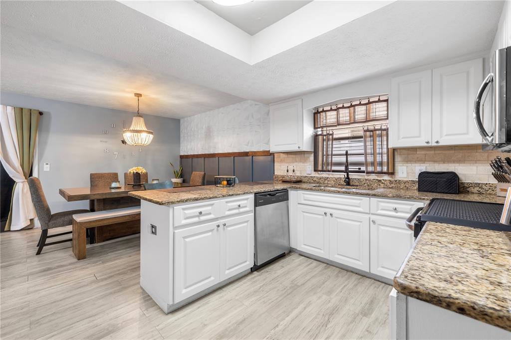 1005 Mook Street Brandon, FL 33510 - Photo 15 of 48 a kitchen with a sink cabinets wooden floor and stainless steel appliances