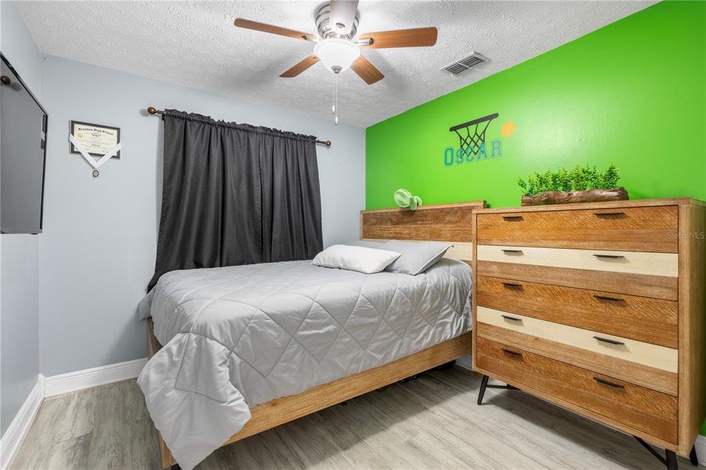 1005 Mook Street Brandon, FL 33510 - Photo 19 of 48 a bedroom with a bed and a ceiling fan