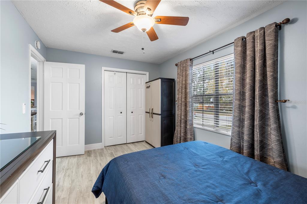 1005 Mook Street Brandon, FL 33510 - Photo 24 of 48 a bedroom with a large bed and a chandelier