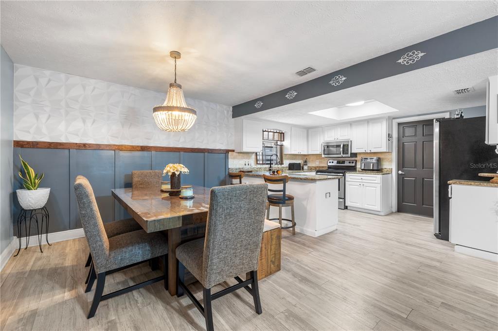 1005 Mook Street Brandon, FL 33510 - Photo 10 of 48 a dining room with furniture a chandelier and wooden floor