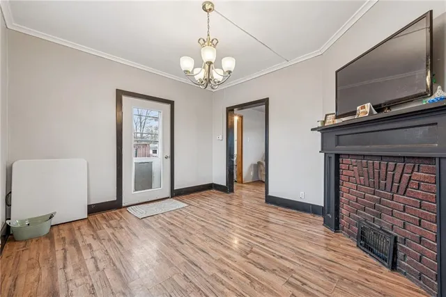 a view of a livingroom with wooden floor and a fireplace