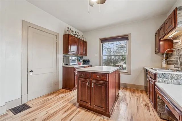 a kitchen with stainless steel appliances granite countertop a refrigerator a sink dishwasher a stove with wooden cabinets and floor