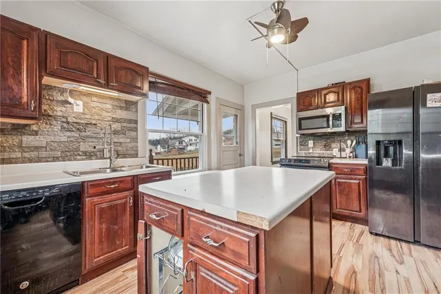 a kitchen with stainless steel appliances granite countertop a sink and cabinets